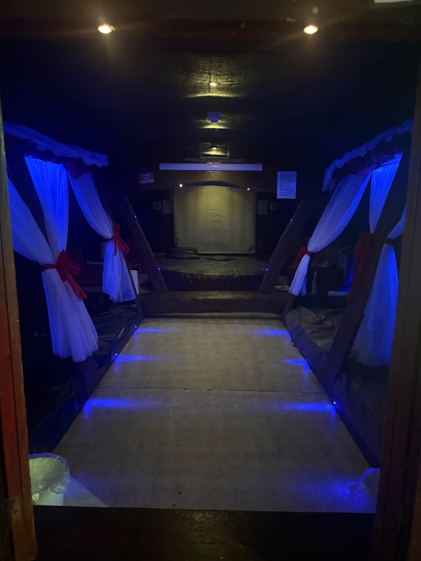 Draped canopy beds lit in soft blue