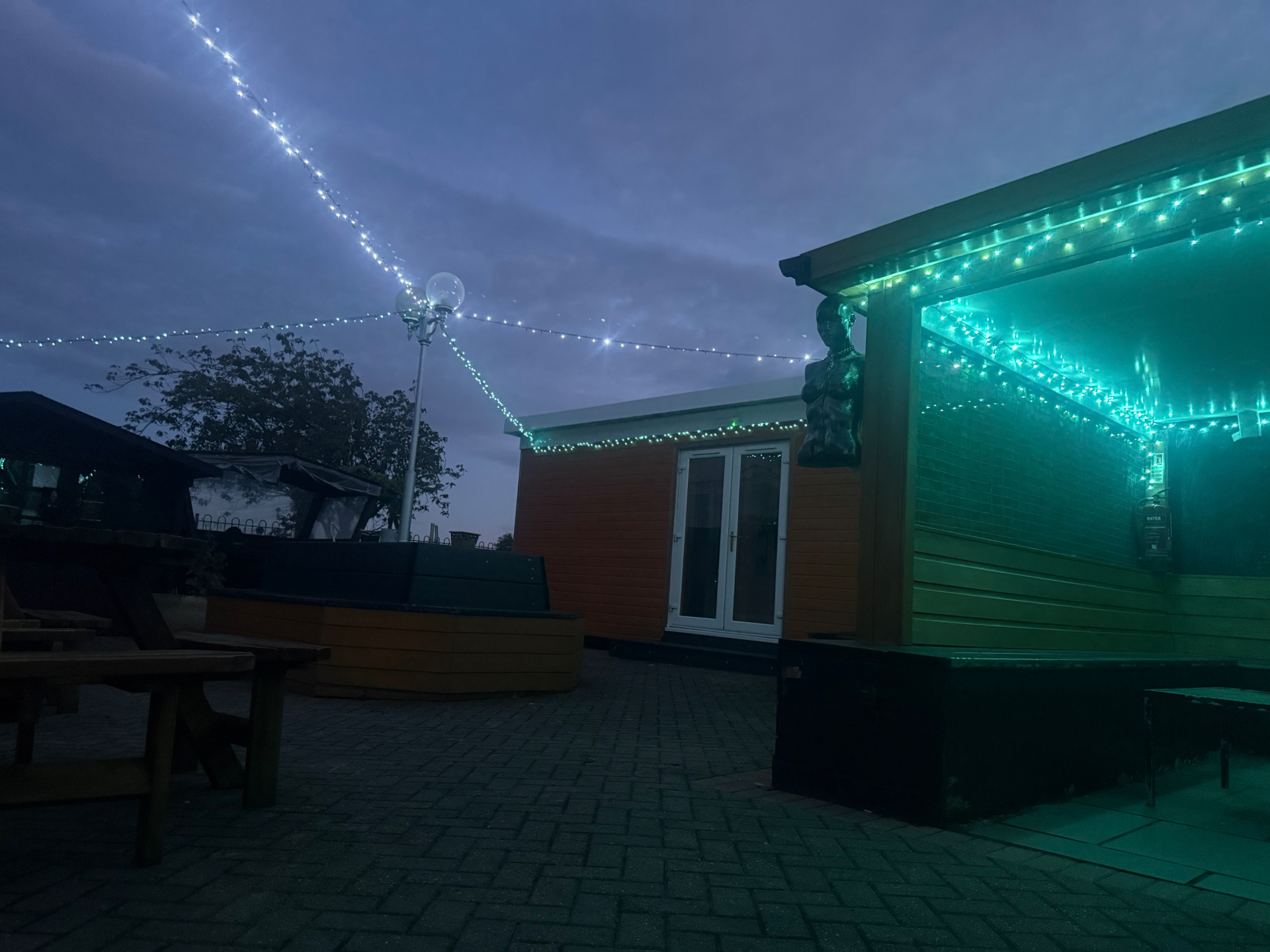Garden cabin at dusk under string lights